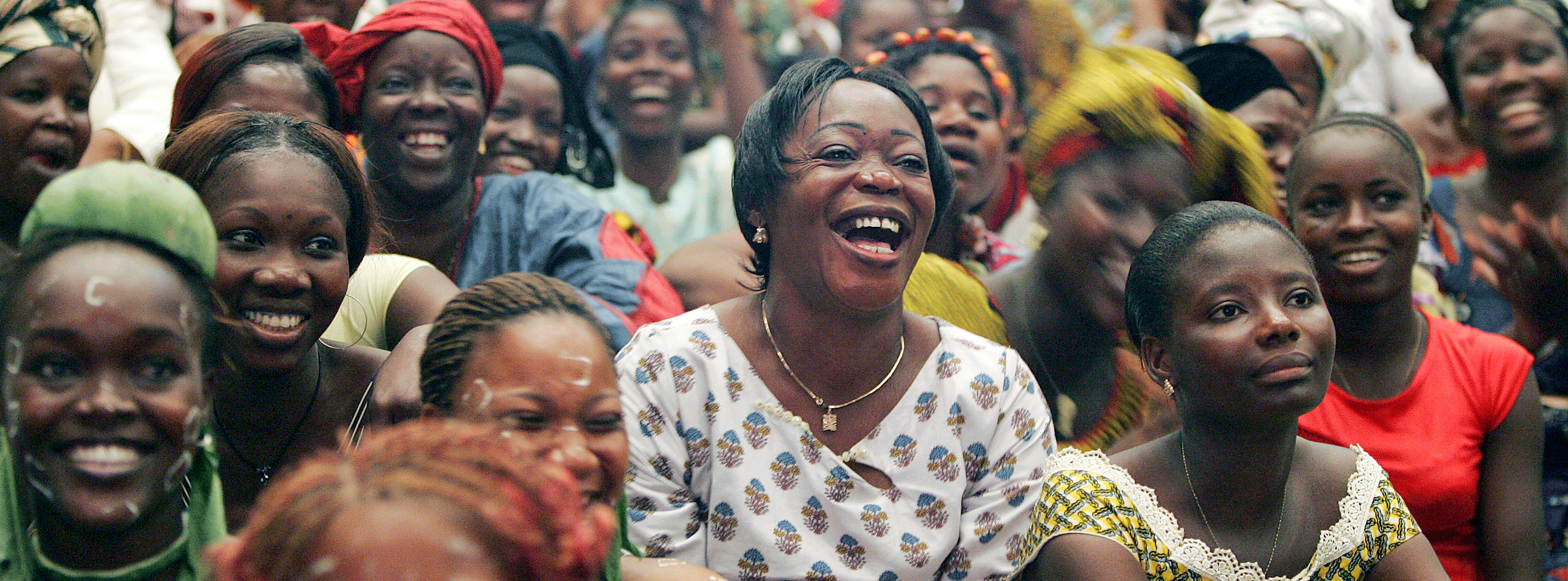 A crowd of women sitting down and laughing.